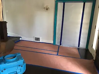 Flooring pulled up and a zippered containment wall set up in a hallway