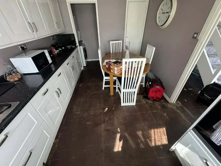 Wet floor along a galley kitchen after a leak under the cabinets