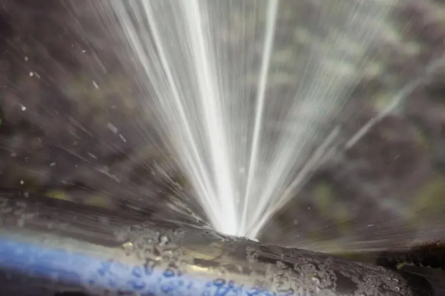 Water spraying from a split pipe under full pressure