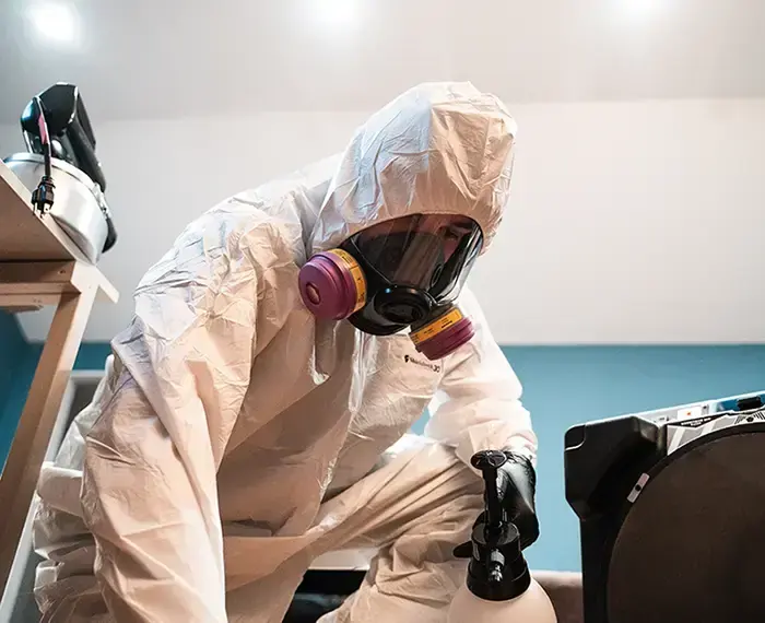 Technician in a protective suit and respirator during a contaminated water cleanup